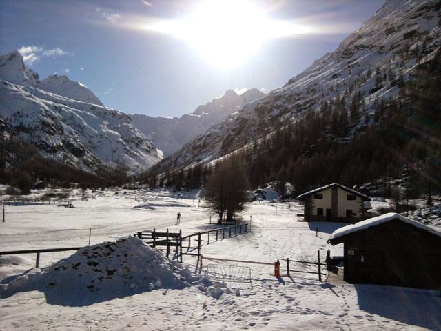 Maison enneigé au fond d'une vallée ensoleillé